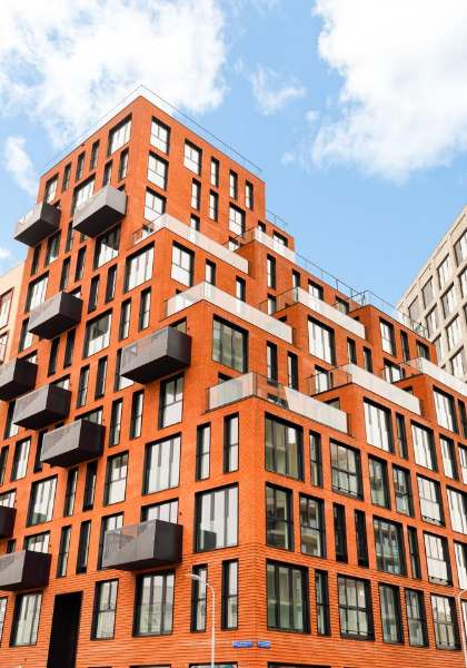 Oranje bakstenen woontoren met balkons